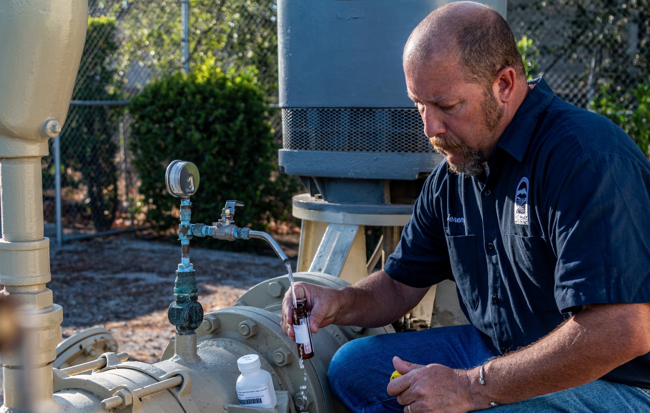 Photo of water quality sample taking place at District site. 